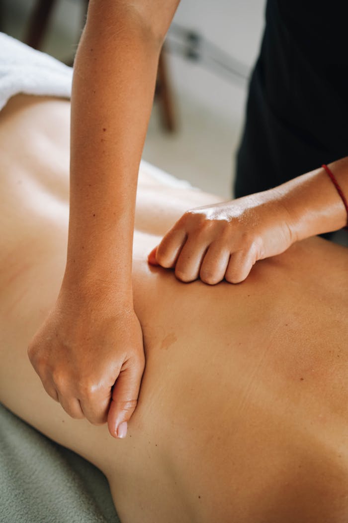 Close-up of a relaxing therapeutic massage focusing on back muscles in a tranquil spa environment.